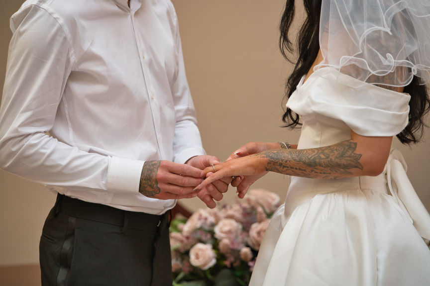 Stockport town hall wedding  the groom places the ring on his new brides finger